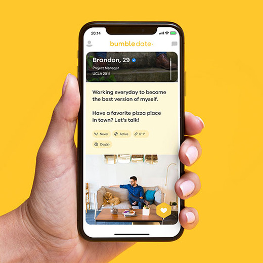 Bumble date profile open on smartphone with hand holding it set on yellow background